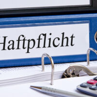 Haftpflicht - Blauer Ordner im Büro Haftpflicht